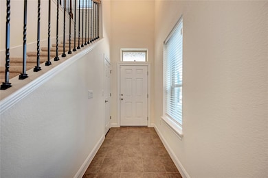Entryway featuring baseboards, a high ceiling, an