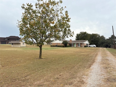 View of green lawn featuring driveway