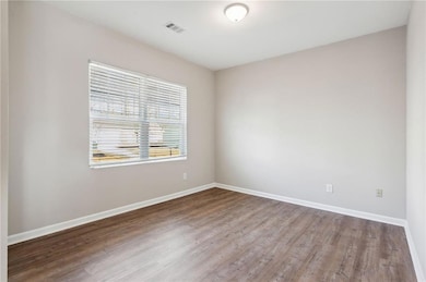 Empty room featuring baseboards, visible vents, an