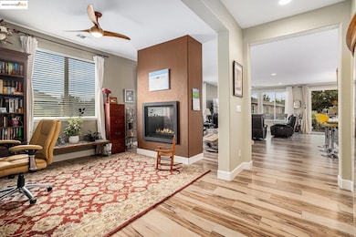 Office space with a multi sided fireplace, light wood finished floors, a ceiling fan, and recessed lighting