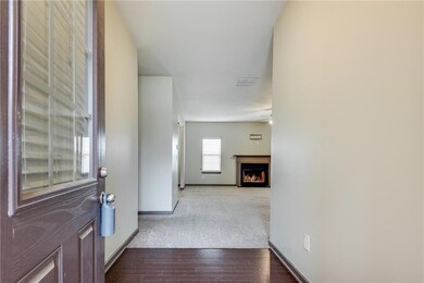 Entrance foyer with a fireplace, carpet flooring, and wood finished floors