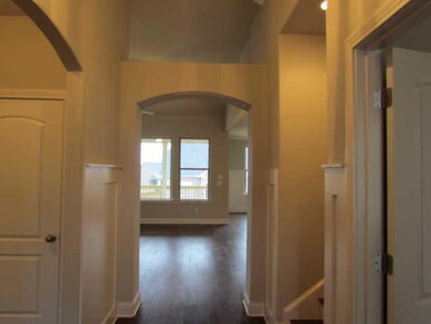 DRAMATIC ENTRY FOYER WITH ARCH OPENING, CROWN MOLDING, AND PANEL DETAIL.