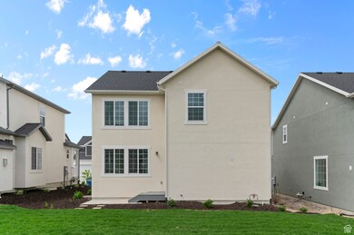Rear view of house with stucco siding and a yard