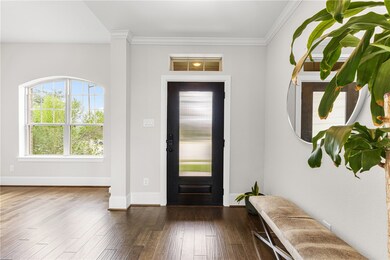 Entryway featuring dark wood-type flooring and ornamental molding