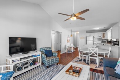 Living room featuring ceiling fan, vaulted ceiling
