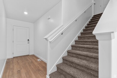 Entrance foyer with dark wood-type flooring and stairs