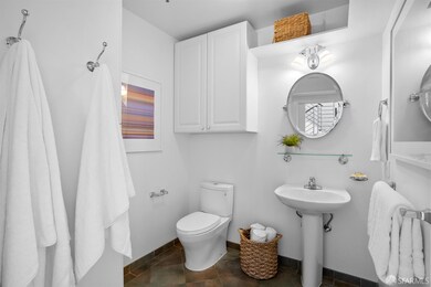 First floor half-bath with additional storage cabinetry, tile flooring and exhaust fan.