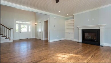 Photo of a similar home showing fireplace and wall unit details with an open floor plan