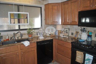 Kitchen with black appliances, sink, tasteful back