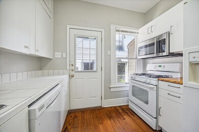 The kitchen has a freestanding gas range, dishwash