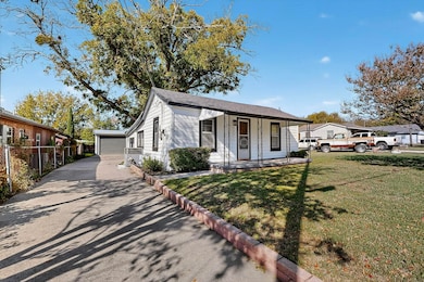 Bungalow with a porch, concrete driveway, and an outdoor structure