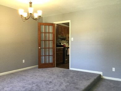 Wood French door leading to kitchen