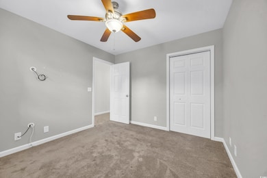 Unfurnished bedroom with carpet, ceiling fan, a cl