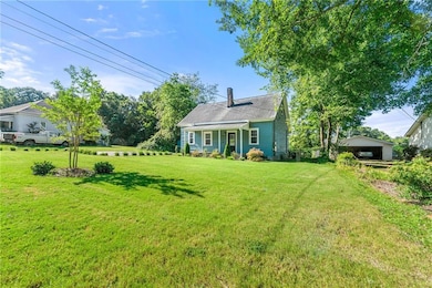 View of front of home featuring a front yard and a chimney