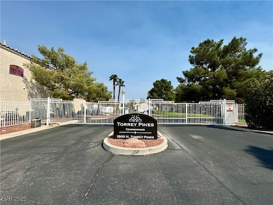 View of asphalt street with a gated entry and curb