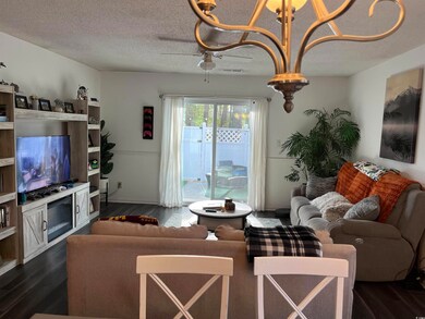 Living room with ceiling fan, dark wood-type floor
