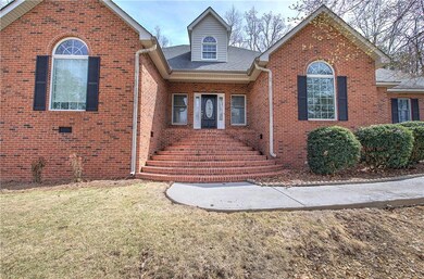 Traditional home with brick siding, a front yard, and roof with shingles