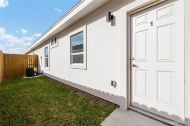 Entrance to property with central AC and stucco siding