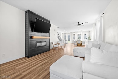 Living area featuring a ceiling fan, a large firep