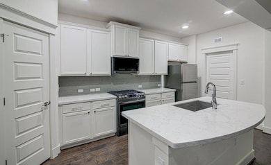 Kitchen featuring white cabinetry, dark wood-type
