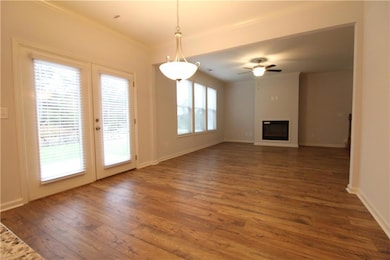 Unfurnished living room featuring a healthy amount of sunlight, dark wood-type flooring, and ceiling fan