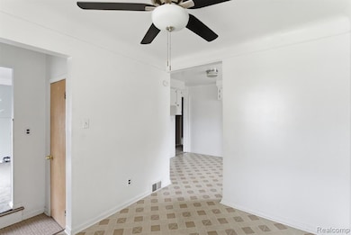 Empty room with ceiling fan and light flooring