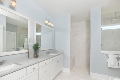 Full bath with double vanity, baseboards, a marble