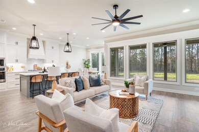 Living room featuring ceiling fan, ornamental mold