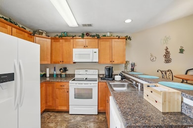 Kitchen featuring a peninsula, a sink, dark counte