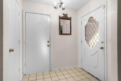 Entrance foyer with baseboards, light tile pattern