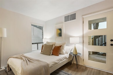 Bedroom featuring wood finished floors and basebo