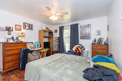 Bedroom with crown molding, a ceiling fan, and dar