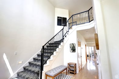 Staircase featuring a high ceiling and wood finished floors