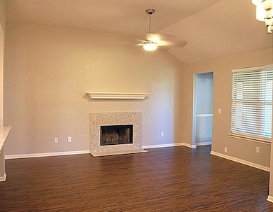 Unfurnished living room with ceiling fan, dark wo