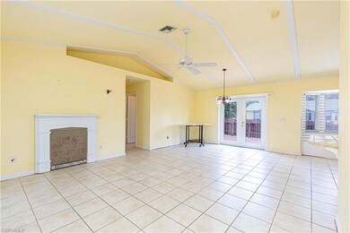 Unfurnished living room with vaulted ceiling, ceiling fan, light tile patterned floors, a fireplace, and baseboards