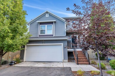Traditional home with stairway, asphalt driveway, a garage, and a shingled roof