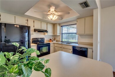 Kitchen features a breakfast bar in foreground and a ceiling fan.