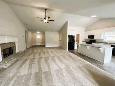 Unfurnished living room with lofted ceiling, a brick fireplace, ceiling fan, and light carpet