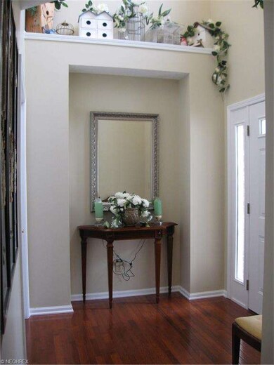 Welcoming and spacious foyer with hardwood flooring.