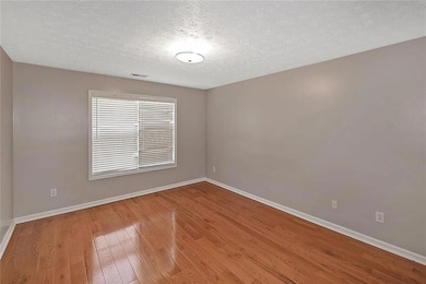 Empty room with baseboards, wood finished floors, 