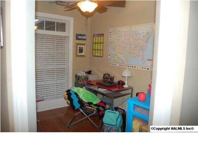 The study has wood flooring, ceiling fan, and smooth ceilings as well.