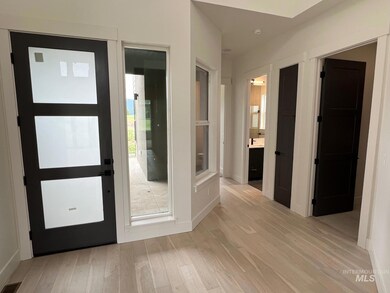 Foyer with light wood-type flooring and baseboards