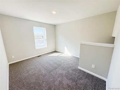 Empty room with carpet floors and baseboards