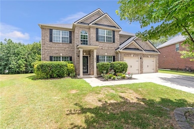 Traditional home with brick siding, concrete driveway, a front lawn, and an attached garage