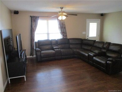 Family room overlooks the front yard, with wood fl