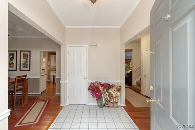 Foyer entrance with crown molding and light hardwo