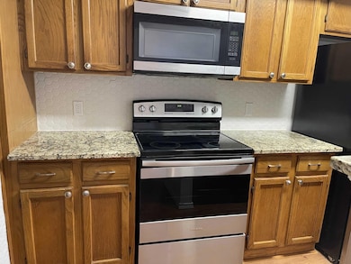 Kitchen with stainless steel appliances, brown cab