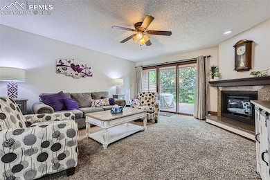Carpeted living room featuring ceiling fan and woo