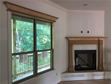 Living room fireplace and windows overlooking the bike trail. 10' ceiling with crown molding. Wood floors.