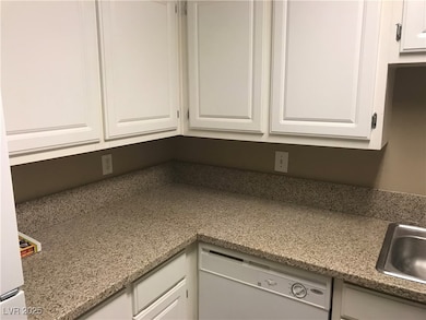 Kitchen featuring light stone countertops, white c
